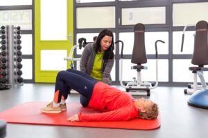 Vrouw met chronische rugklachten doet oefeningen met een fysiotherapeut.