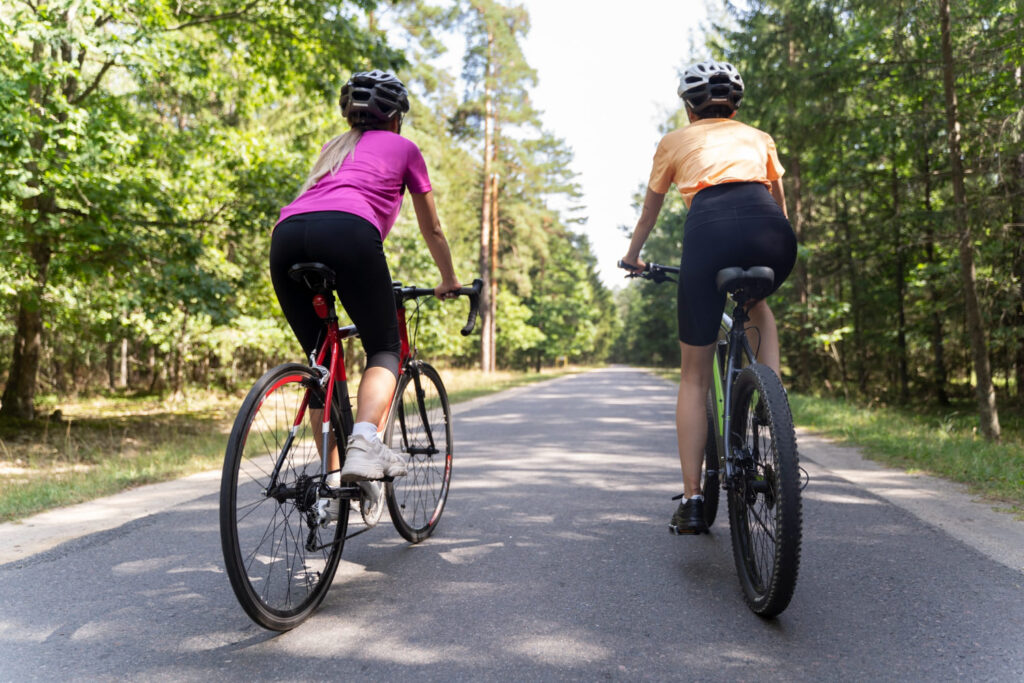 2 mensen zijn aan het fietsen en hebben last van rugpijn tijdens het fietsen