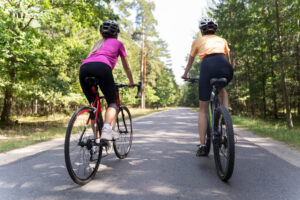 2 mensen zijn aan het fietsen en hebben last van rugpijn tijdens het fietsen